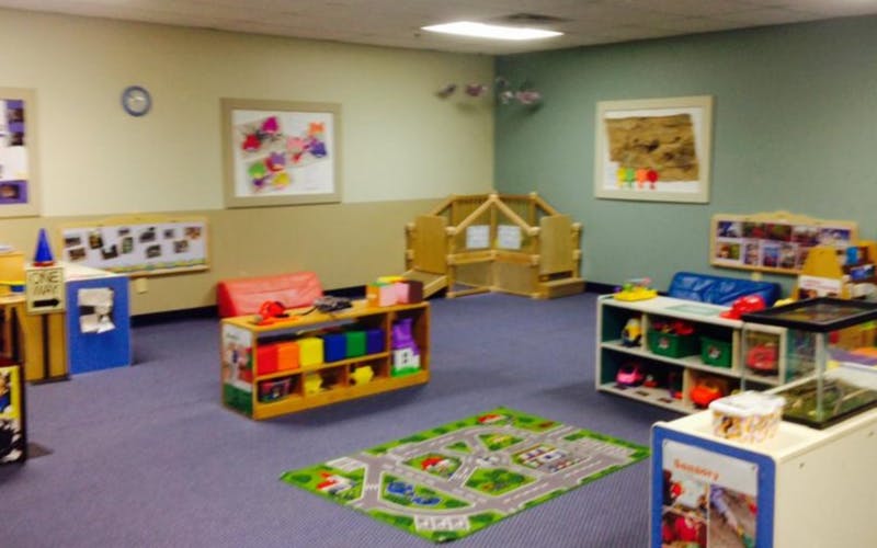 A children's classroom with toys, storage, and artwork on the walls
