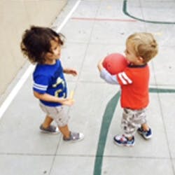 Two children playing with a ball