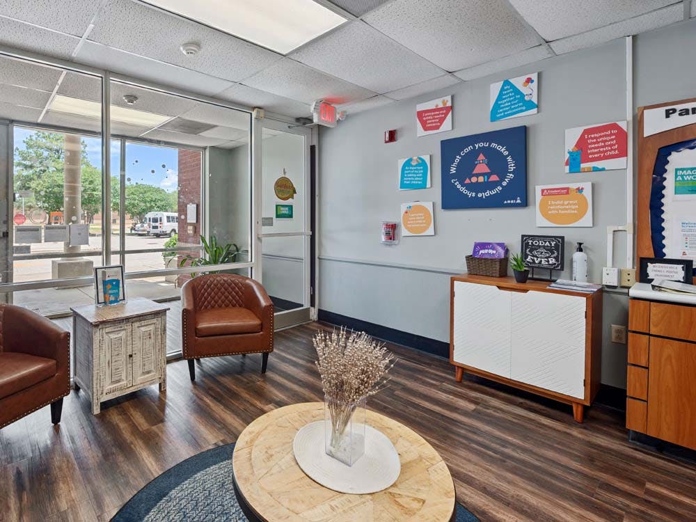 Lobby waiting area with chairs, tables, and windows looking out to a street