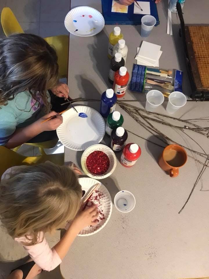 Two children painting and crafting at a table