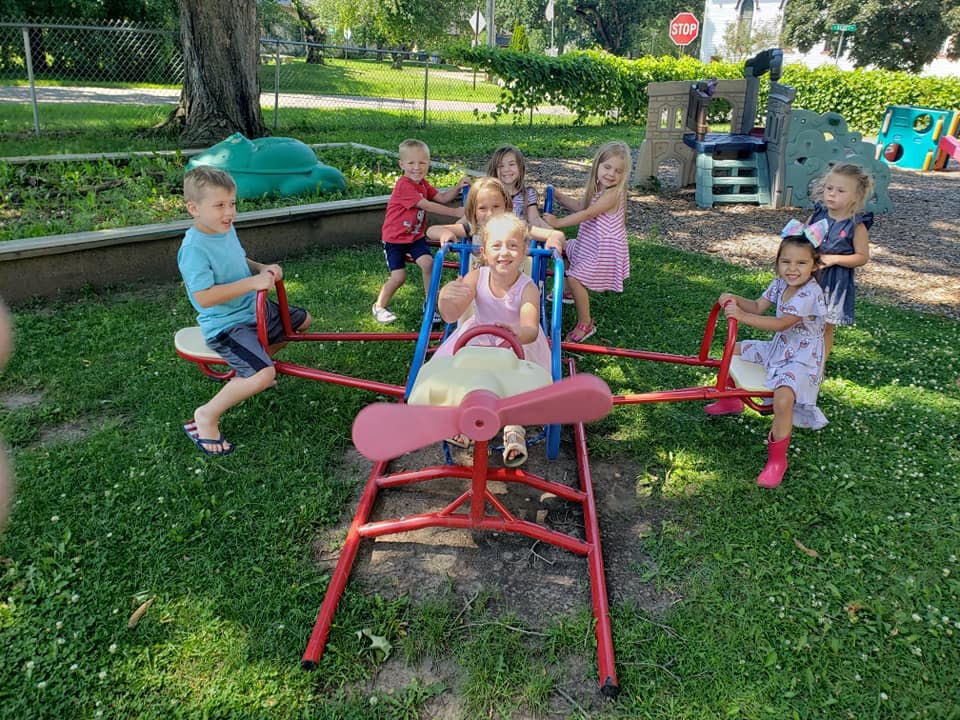 Children playing on a seesaw and other playground equipment
