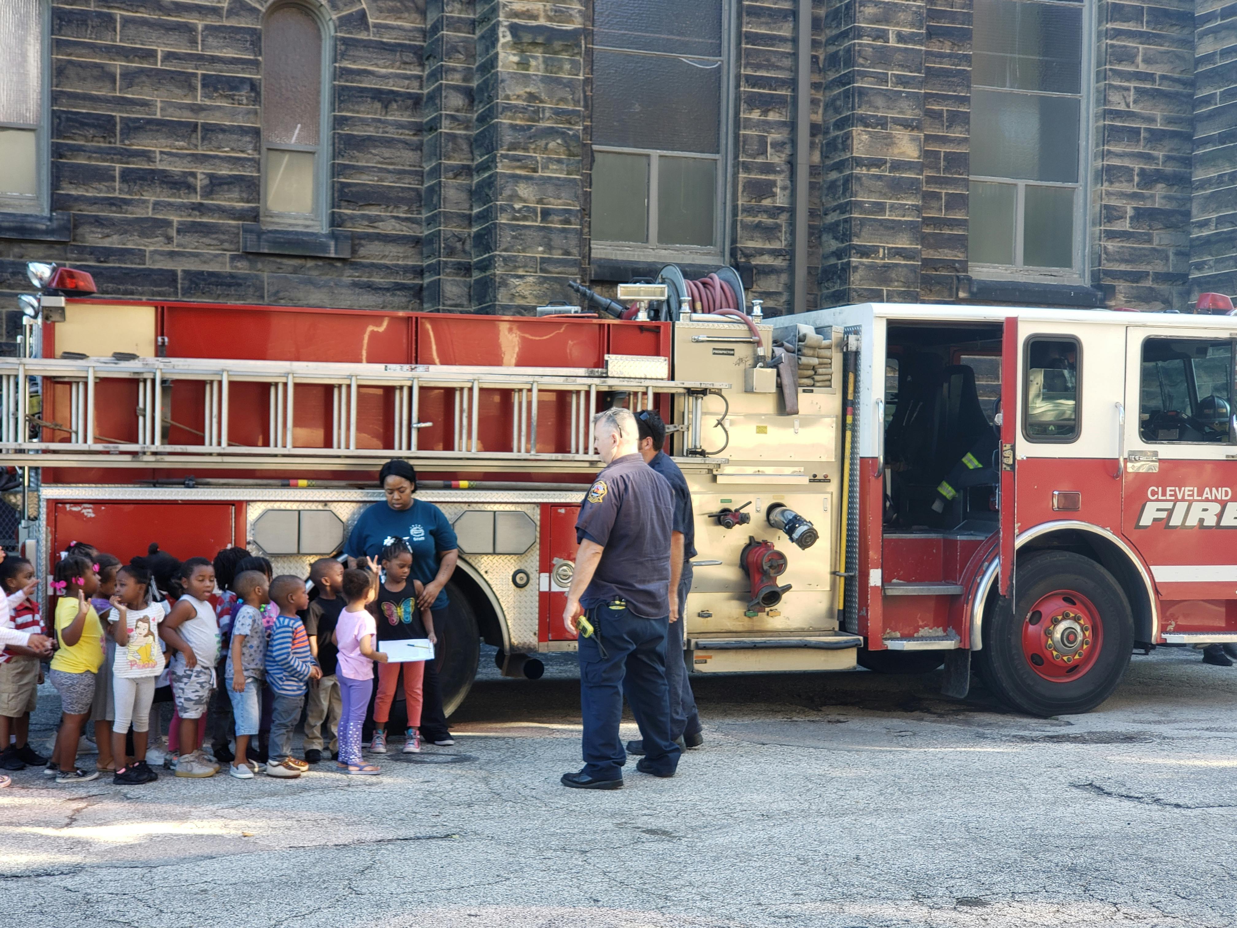 People and children standing next to a fire truck