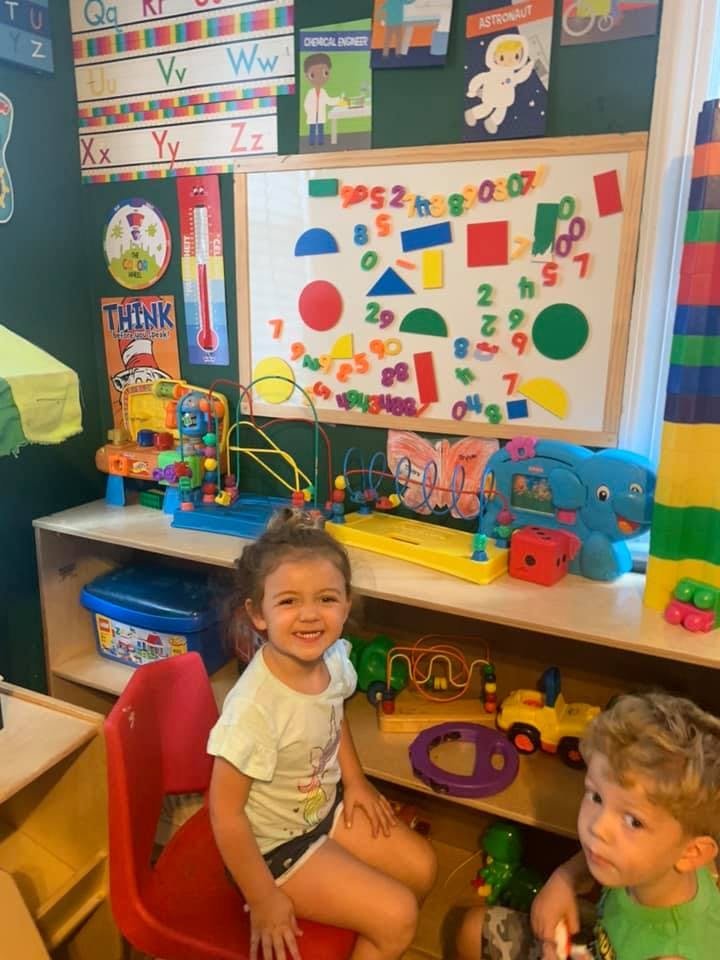 Two children in a classroom with toys and learning materials
