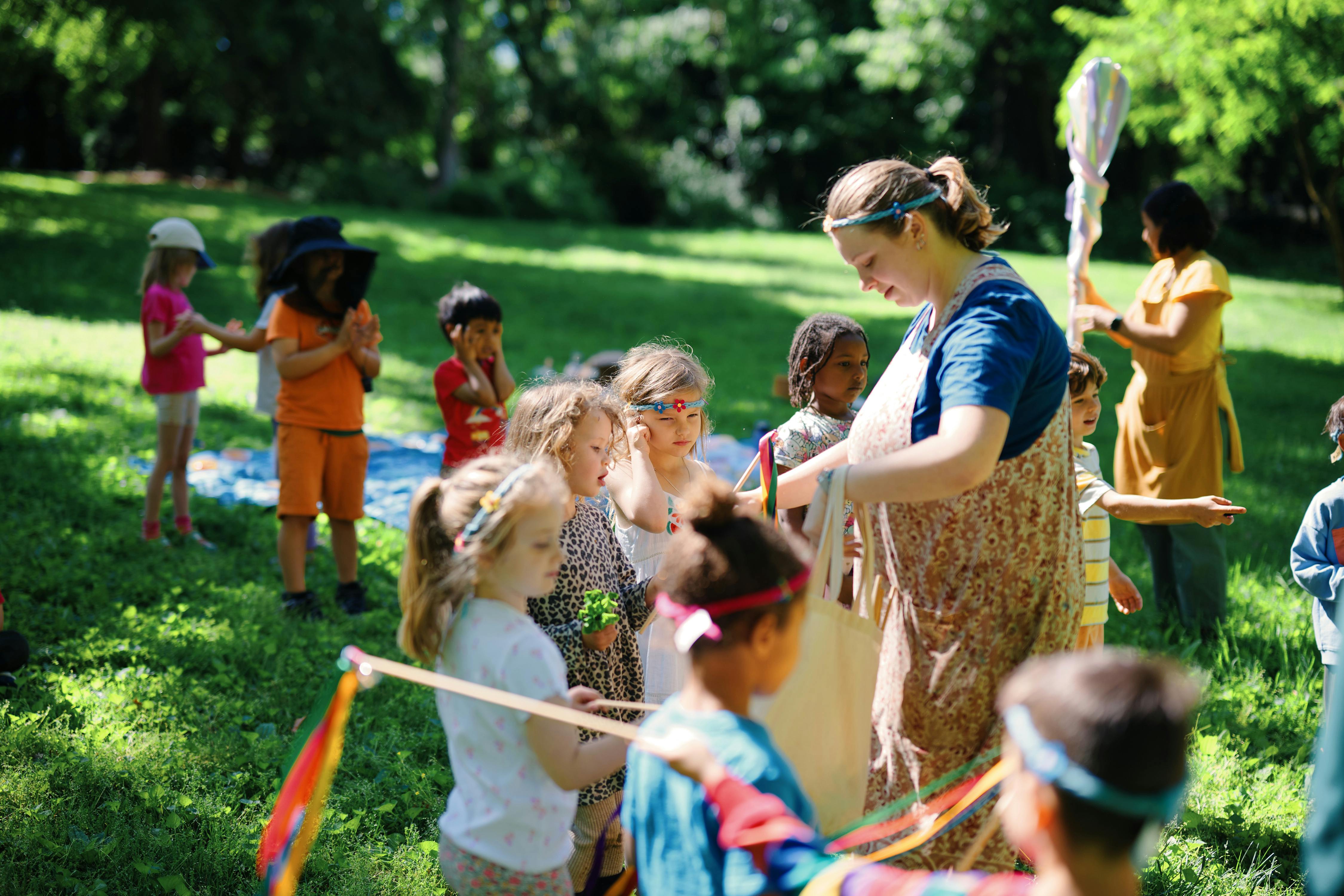 Adult leading a group of children in an outdoor activity