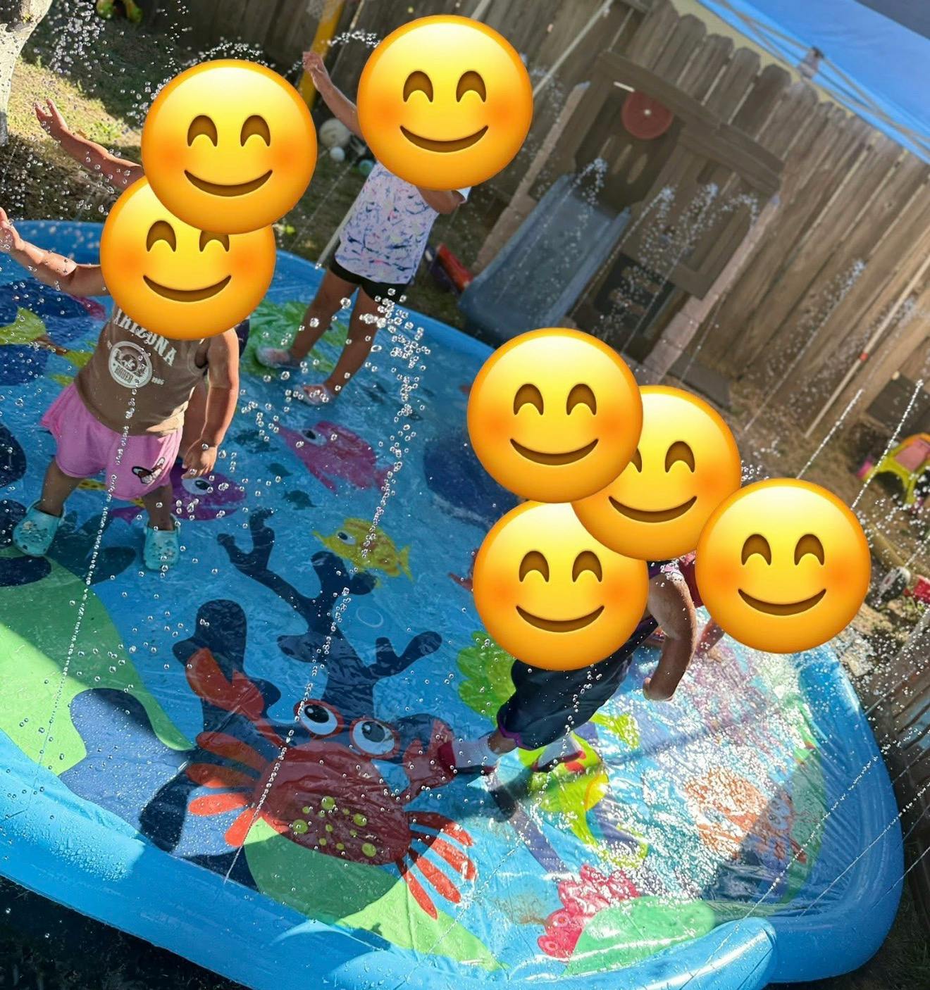 Children playing in a splash pad with water spraying