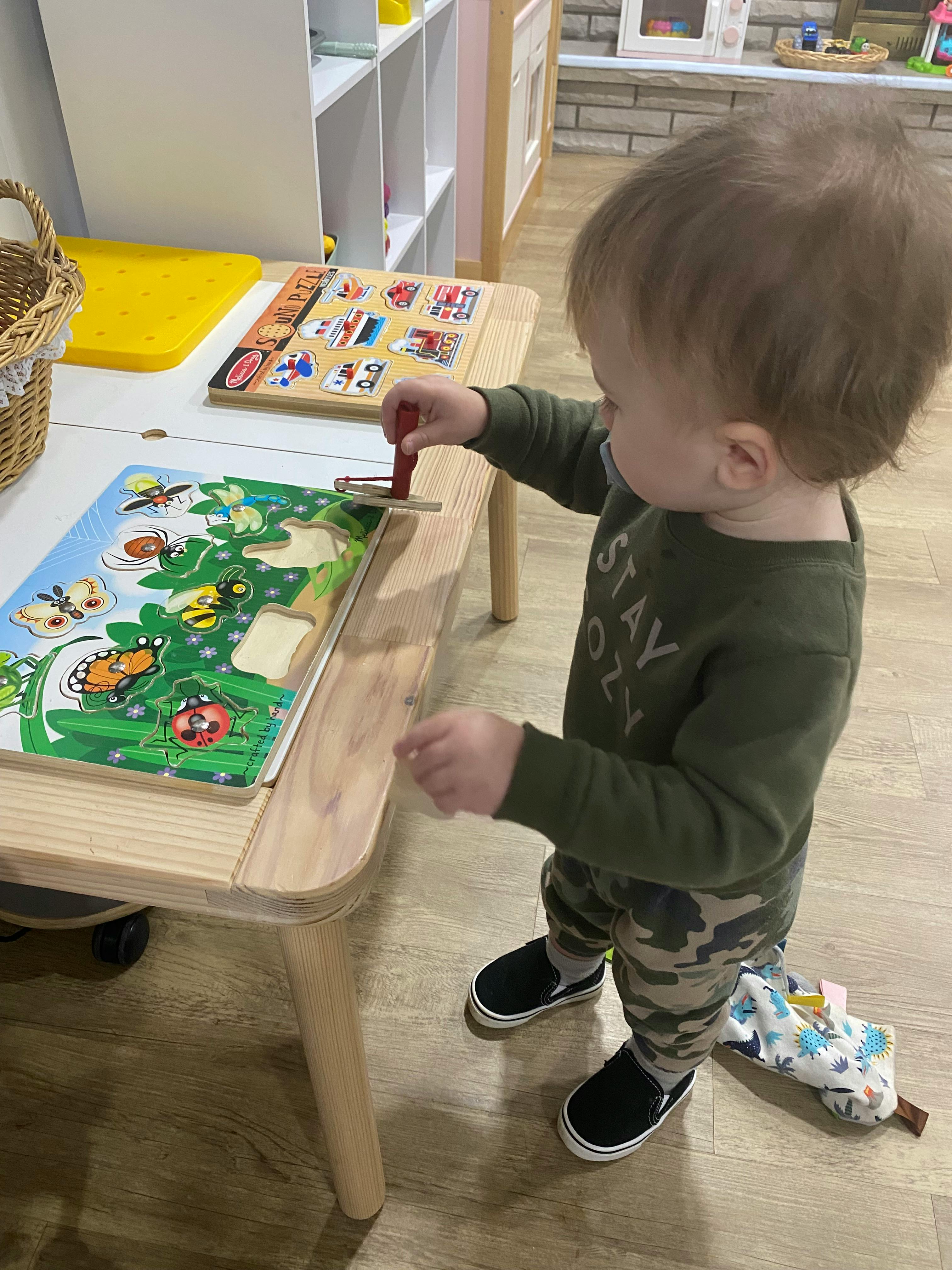 Child playing with a puzzle at a small table