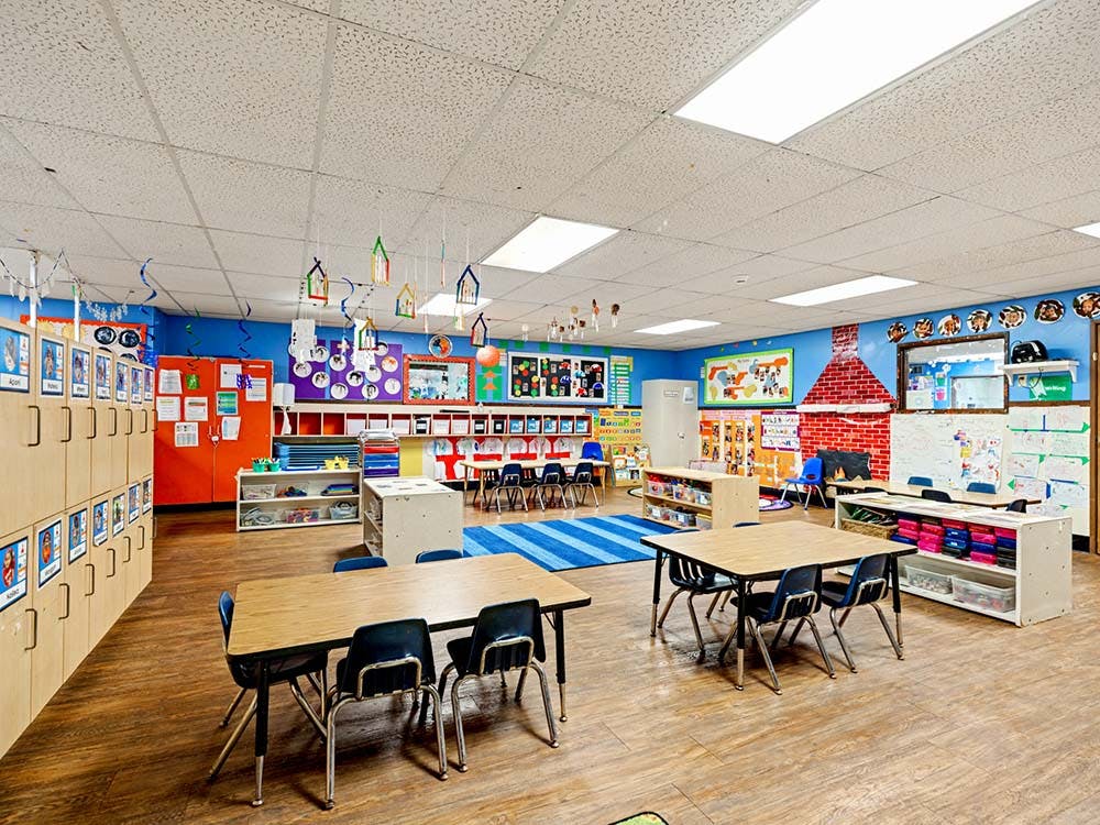 Empty colorful classroom with small tables and chairs
