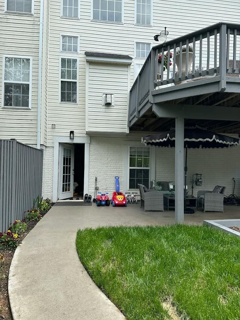 Patio with outdoor seating, a deck above, and children's ride-on toys