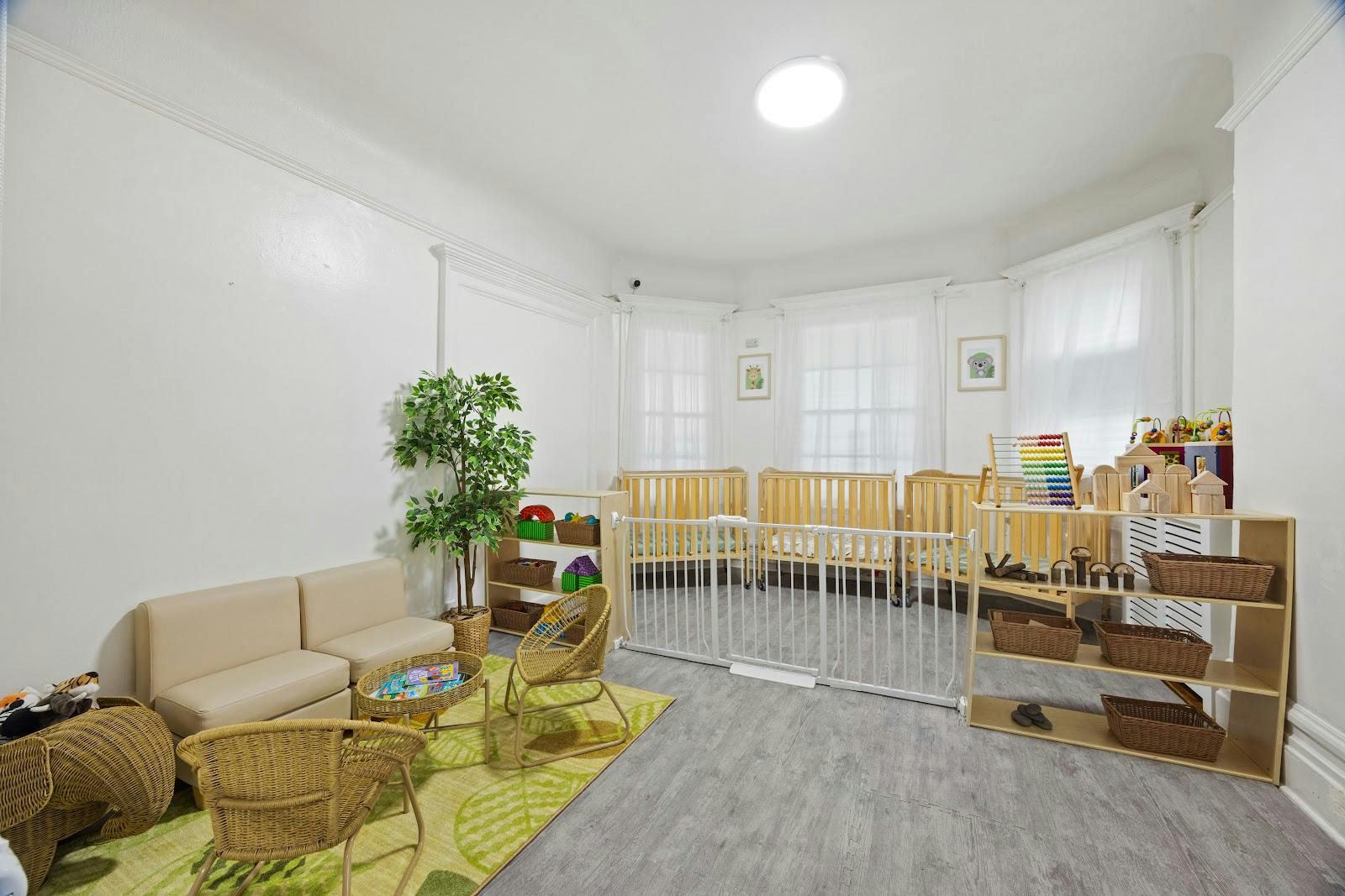 Childcare room with wooden cribs, toy shelves, and seating area