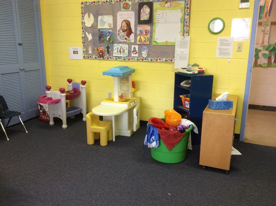 Playroom with toy kitchen, toy crib, and bulletin board