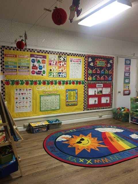 Classroom with bulletin boards and a colorful rug