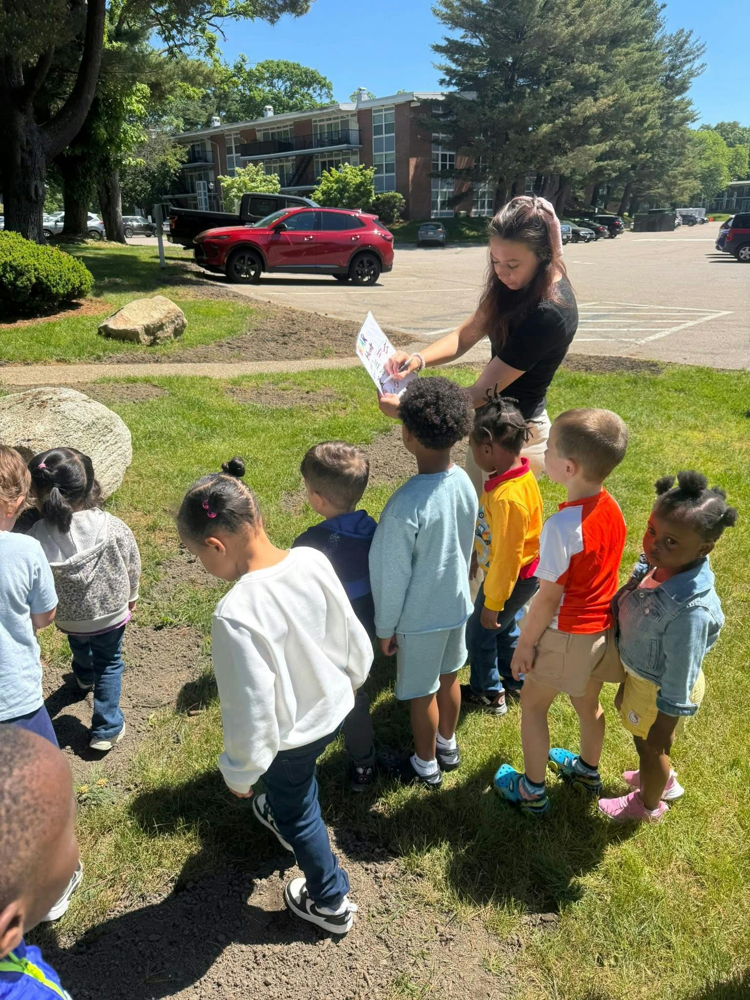 Adult person interacting with a group of children outdoors