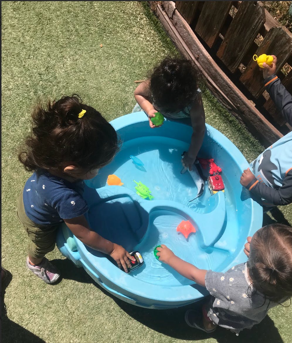 Children playing with toys in a water table