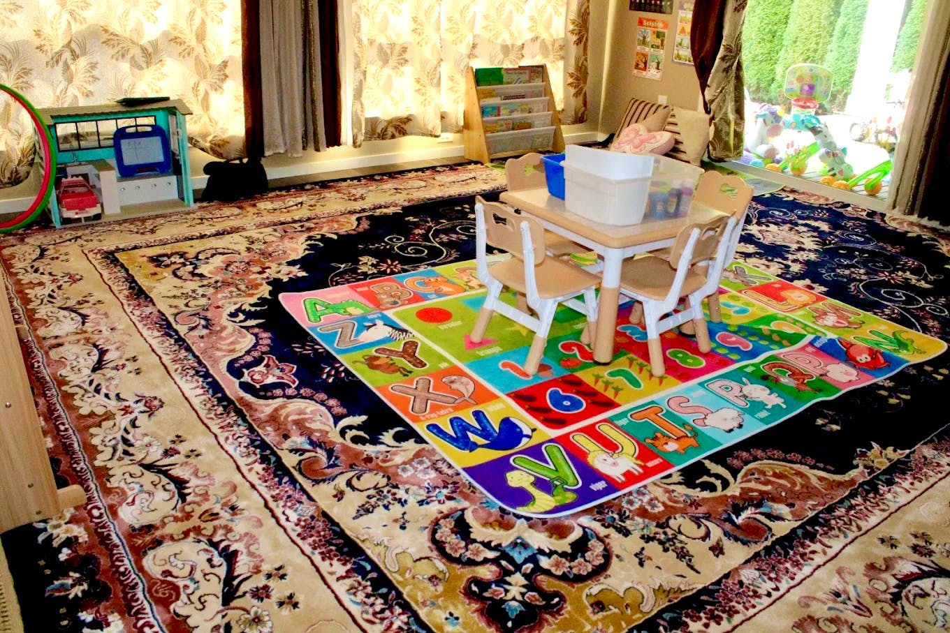 Small table and chairs on a colorful alphabet rug in a room