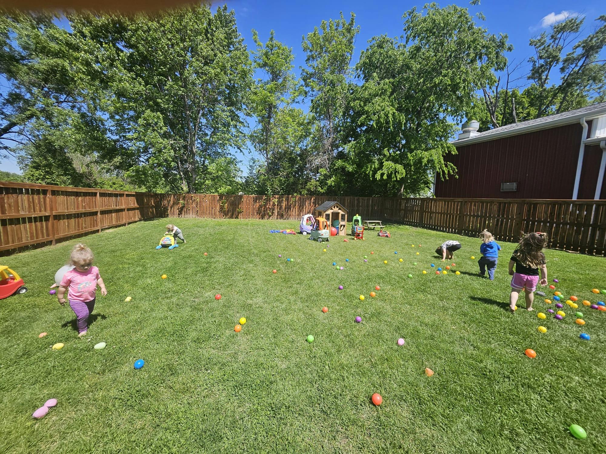 Children playing with colorful balls in a grassy yard