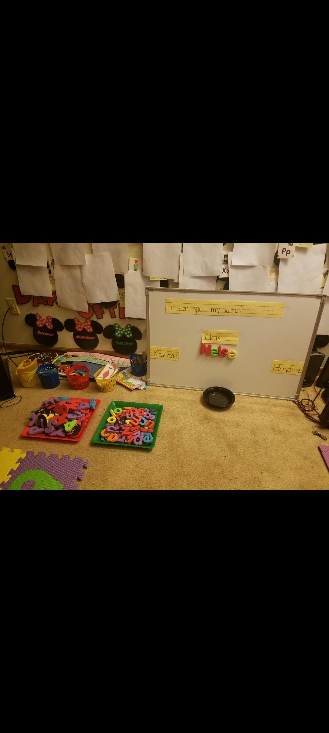 Classroom with whiteboard, colorful letters, and play mats