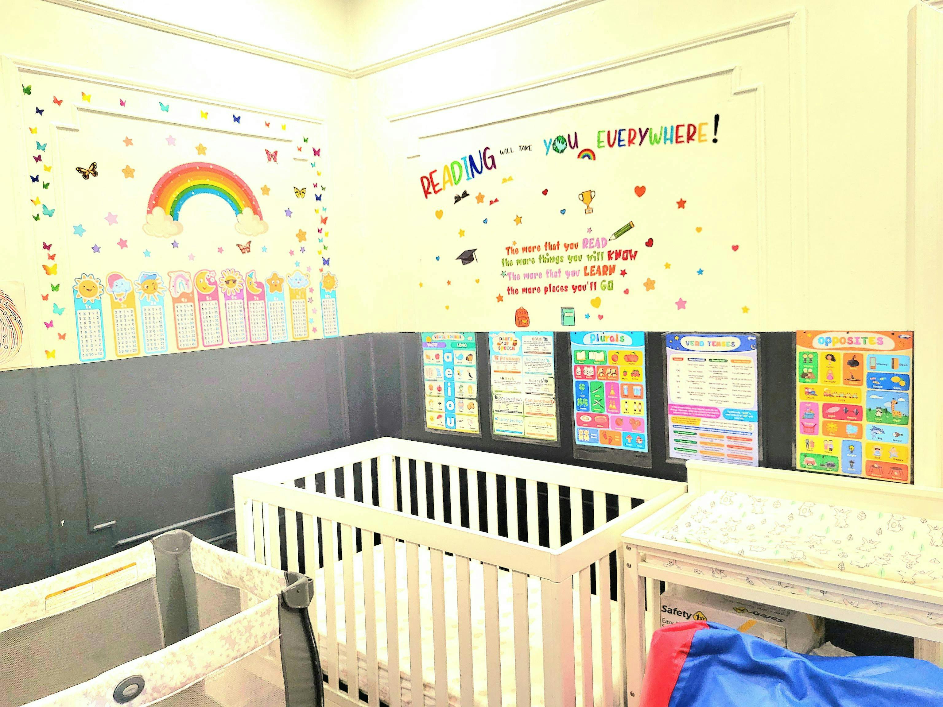 Cribs in a room with colorful wall decorations and charts