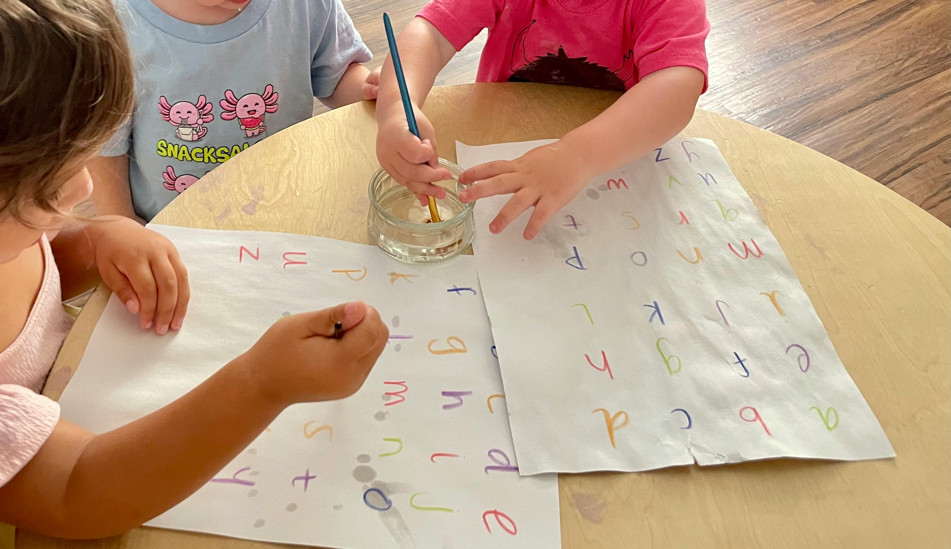 Children painting letters on paper