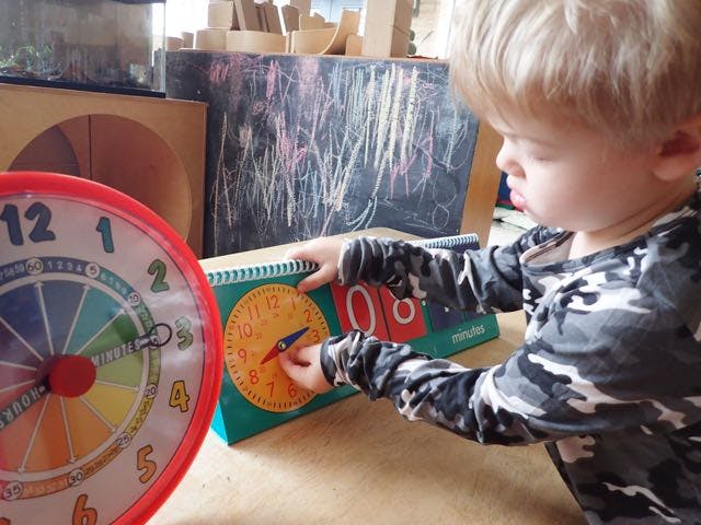Child playing with a learning clock