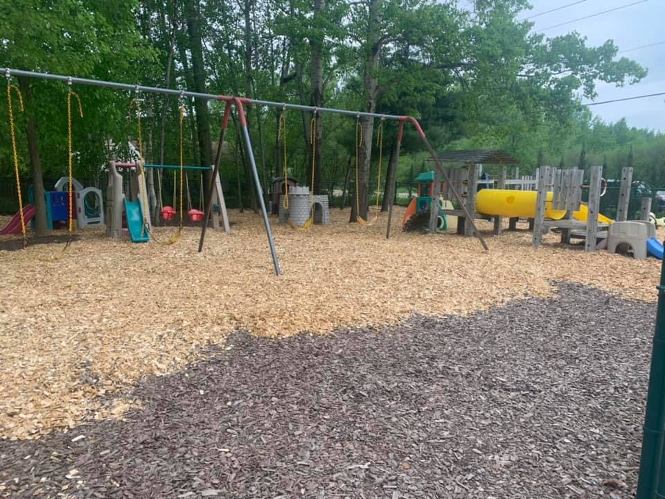 Playground with swings and play structure on wood chips