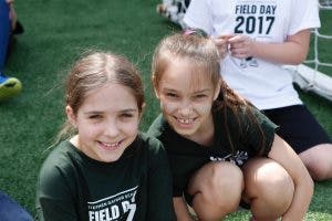 Two children smiling on a field