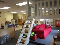 Indoor play structure with a red couch underneath