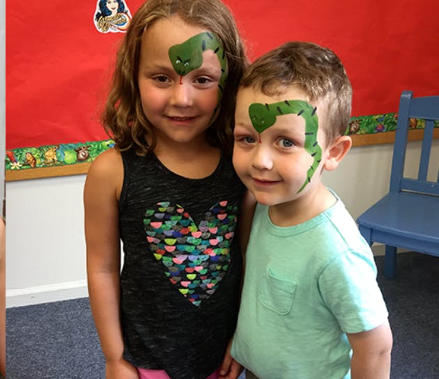 Two children with green snake face paint