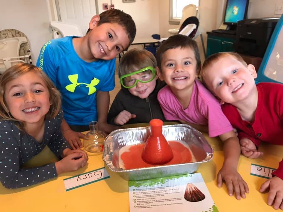 Five children around a table with a science experiment