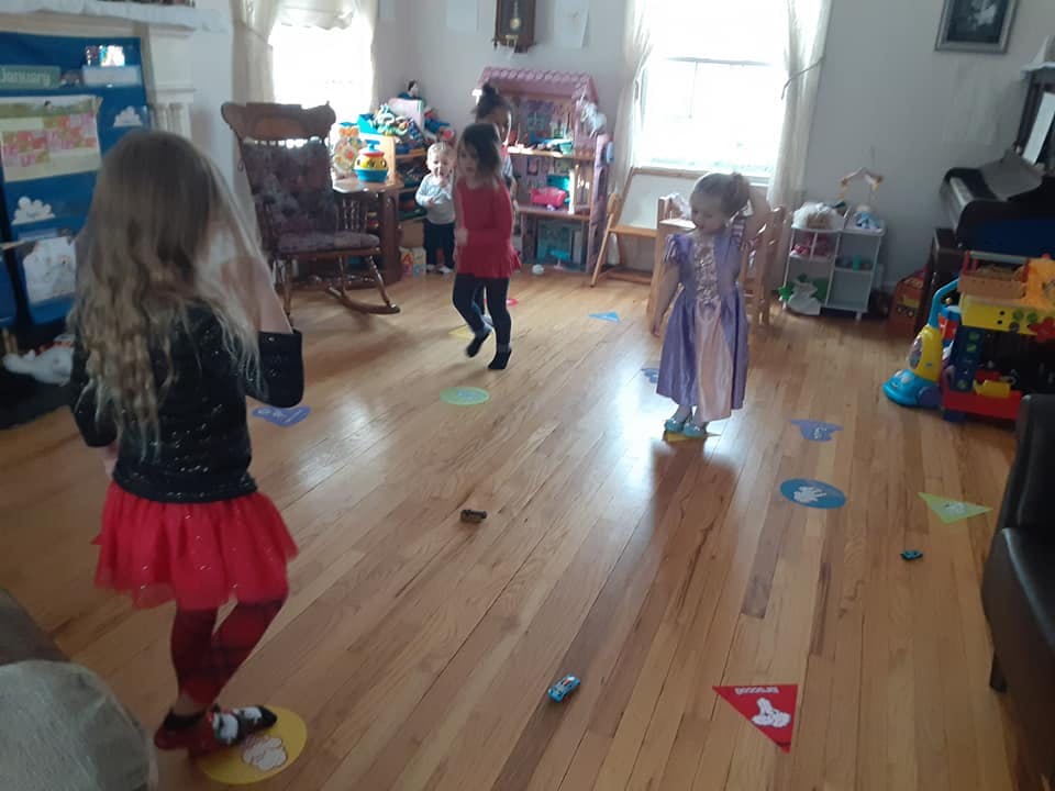 Children playing on a wooden floor with colorful markers