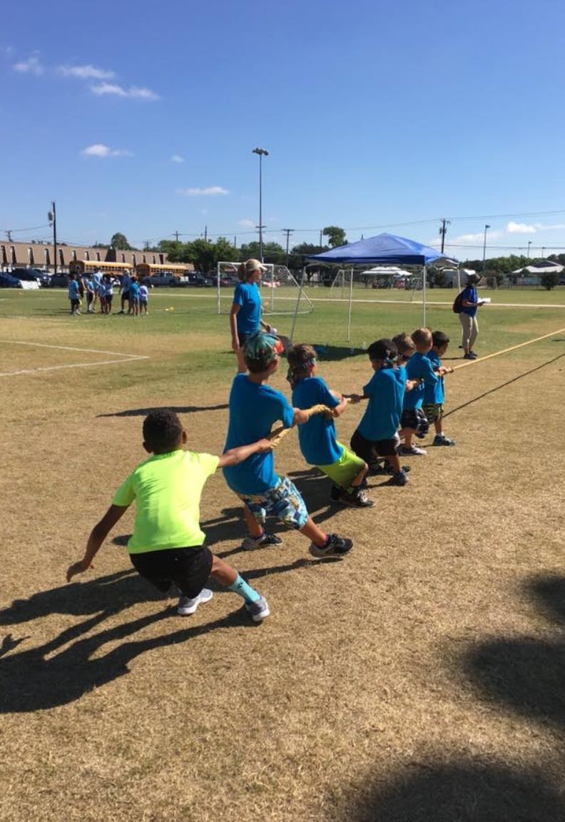 Children playing tug-of-war on a grassy field