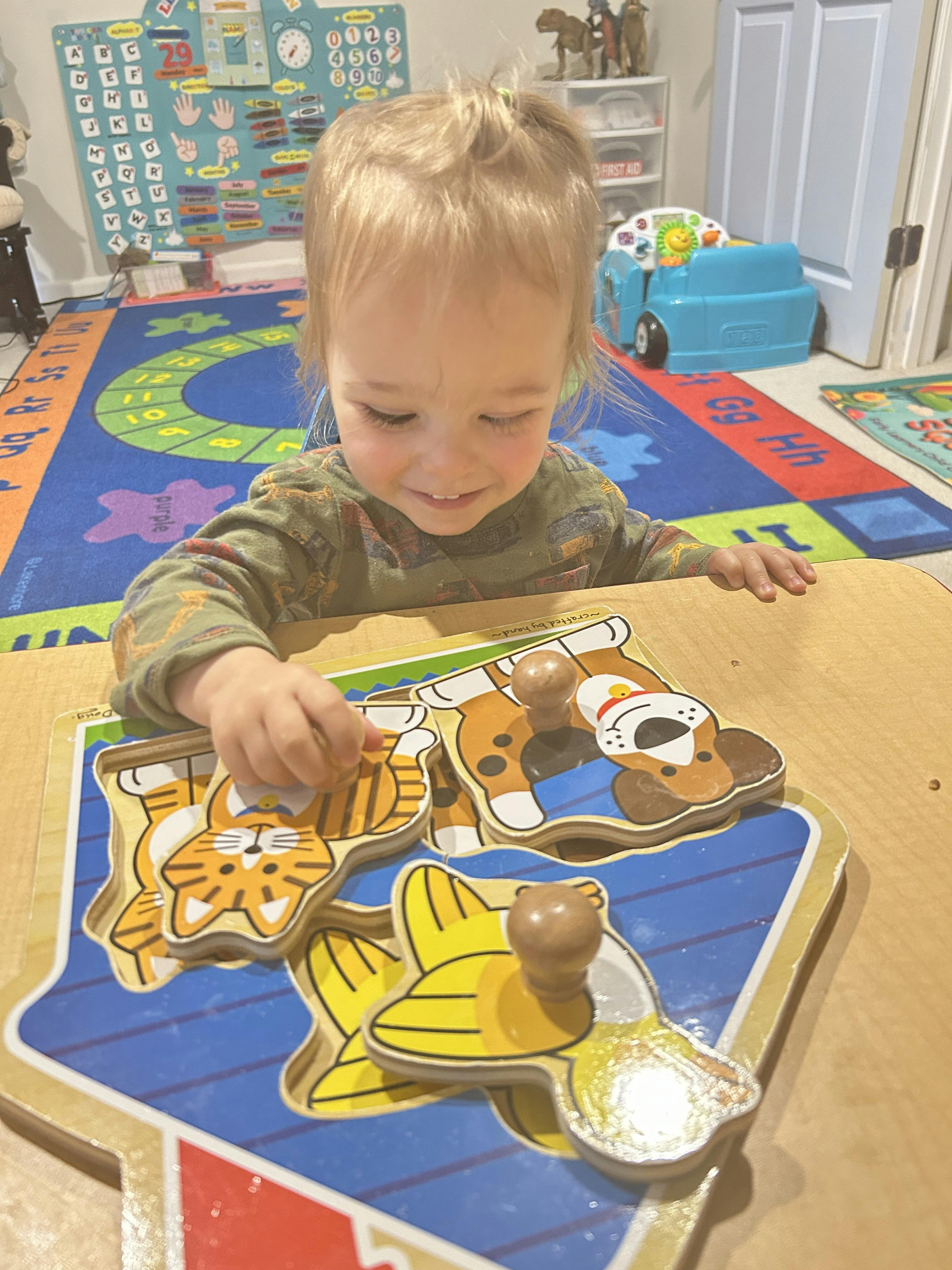 Child playing with an animal-shaped wooden puzzle