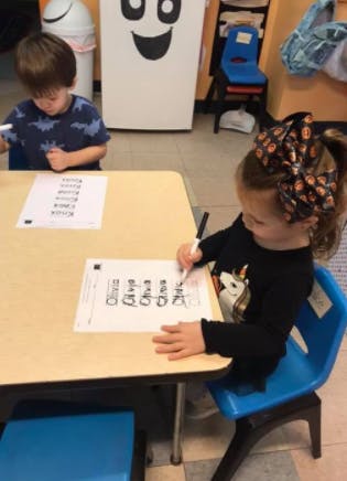 Two children sitting at a table doing schoolwork