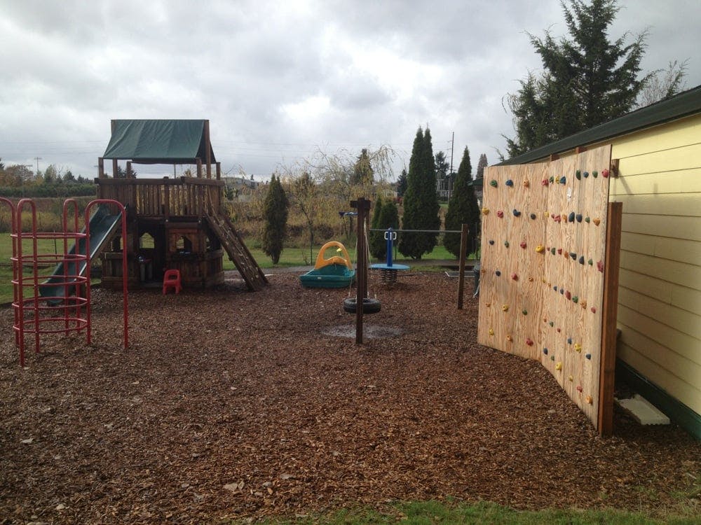 Playground with climbing structure, slide, monkey bars, and climbing wall