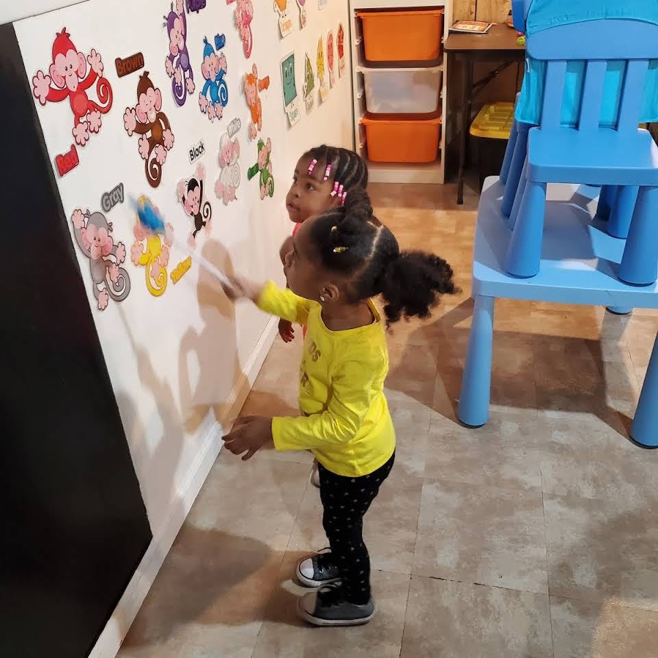 Two children playing with wall decals