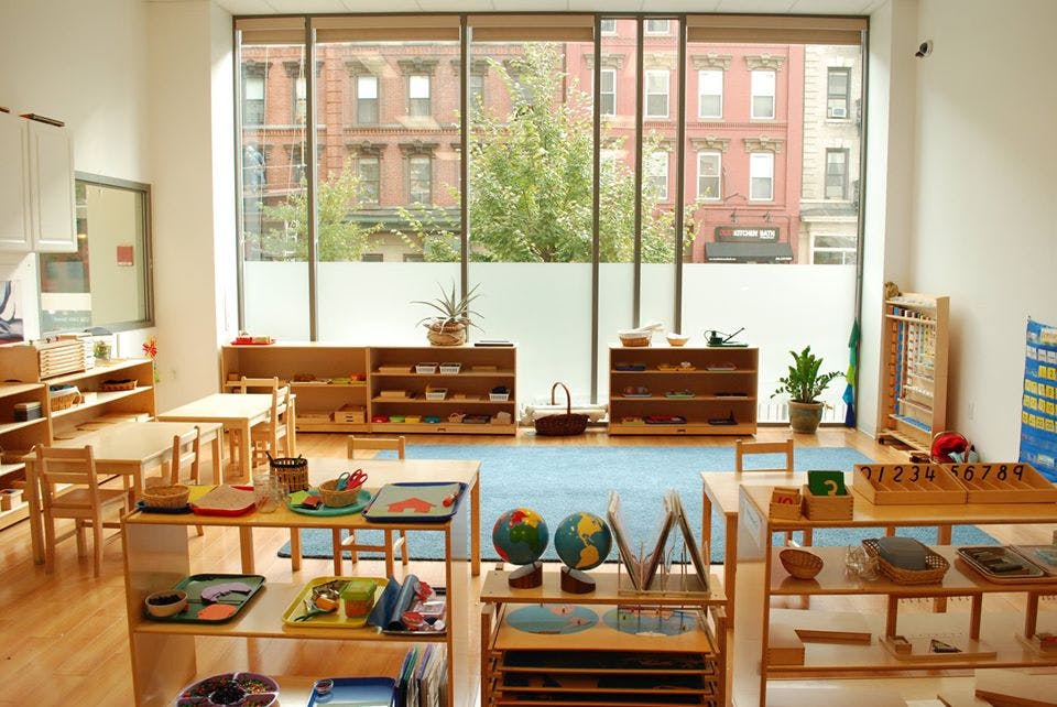 Classroom with wooden shelves, tables, and learning materials