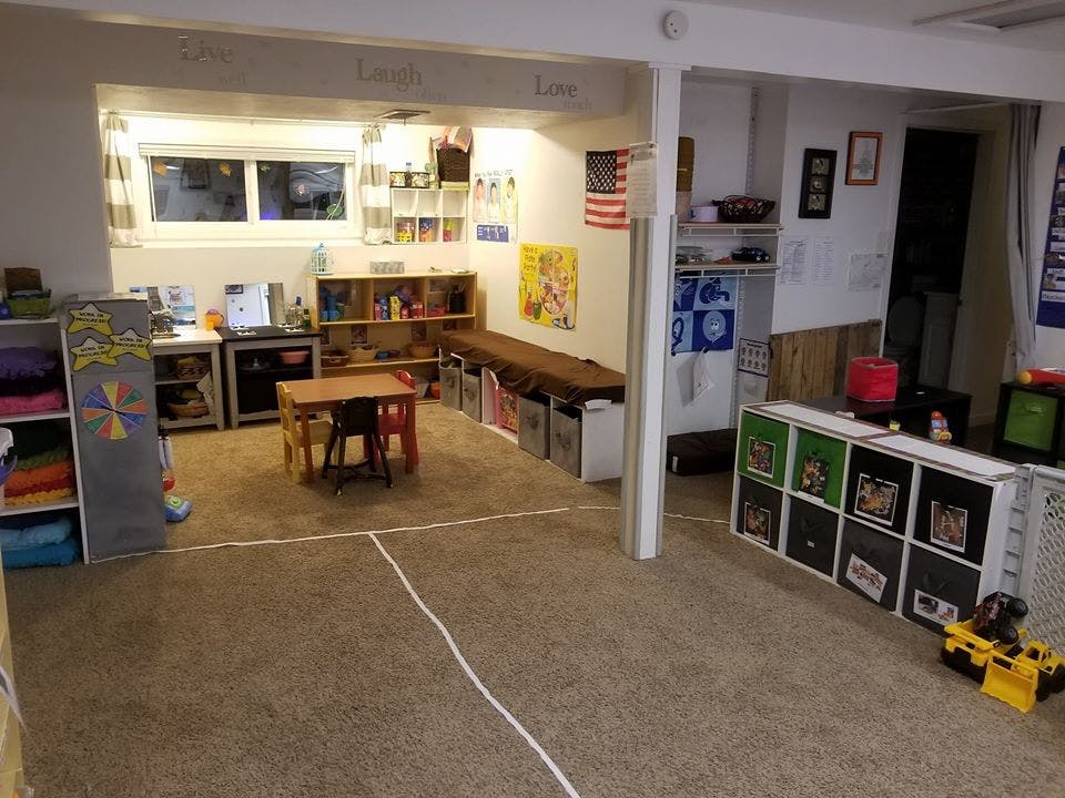 Playroom with small table and chairs, shelves, and storage bins