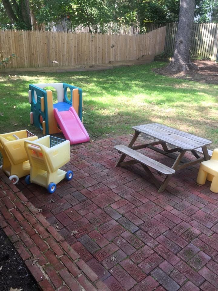 Outdoor play area with a slide, two toy shopping carts, and a picnic table