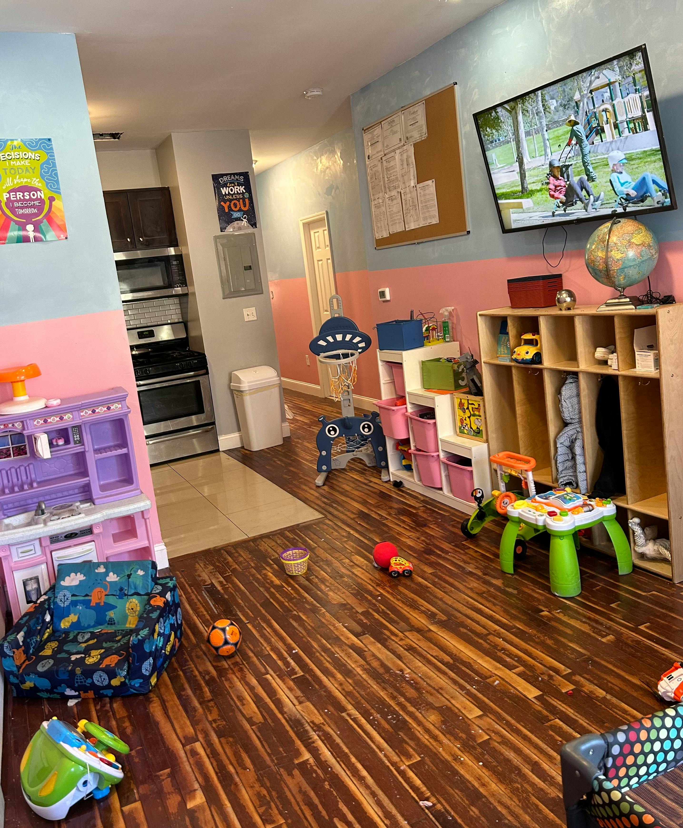 Playroom with toys, a television, and a play kitchen