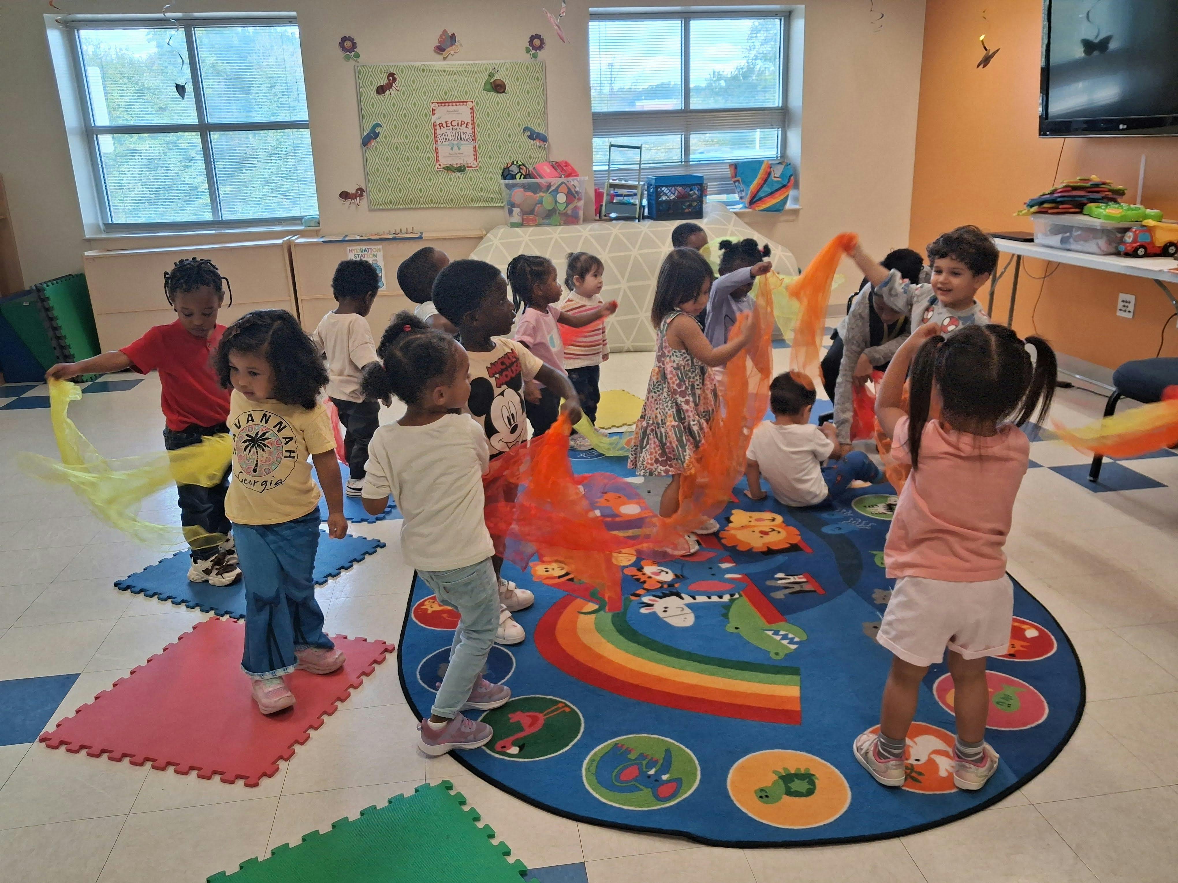 Children playing with colorful scarves in a classroom