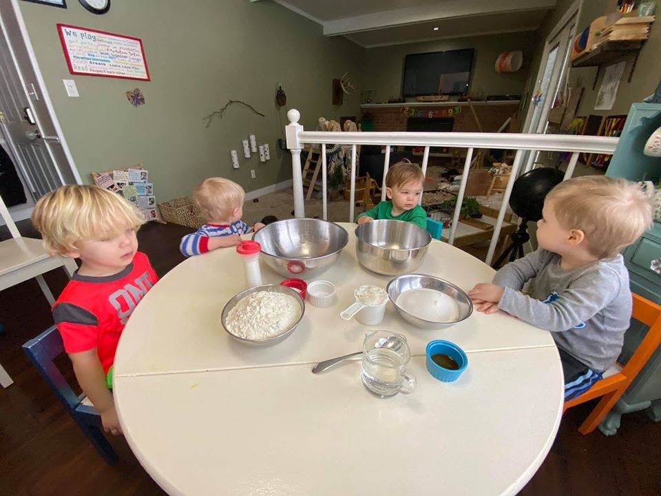 Three children at a table with bowls of ingredients