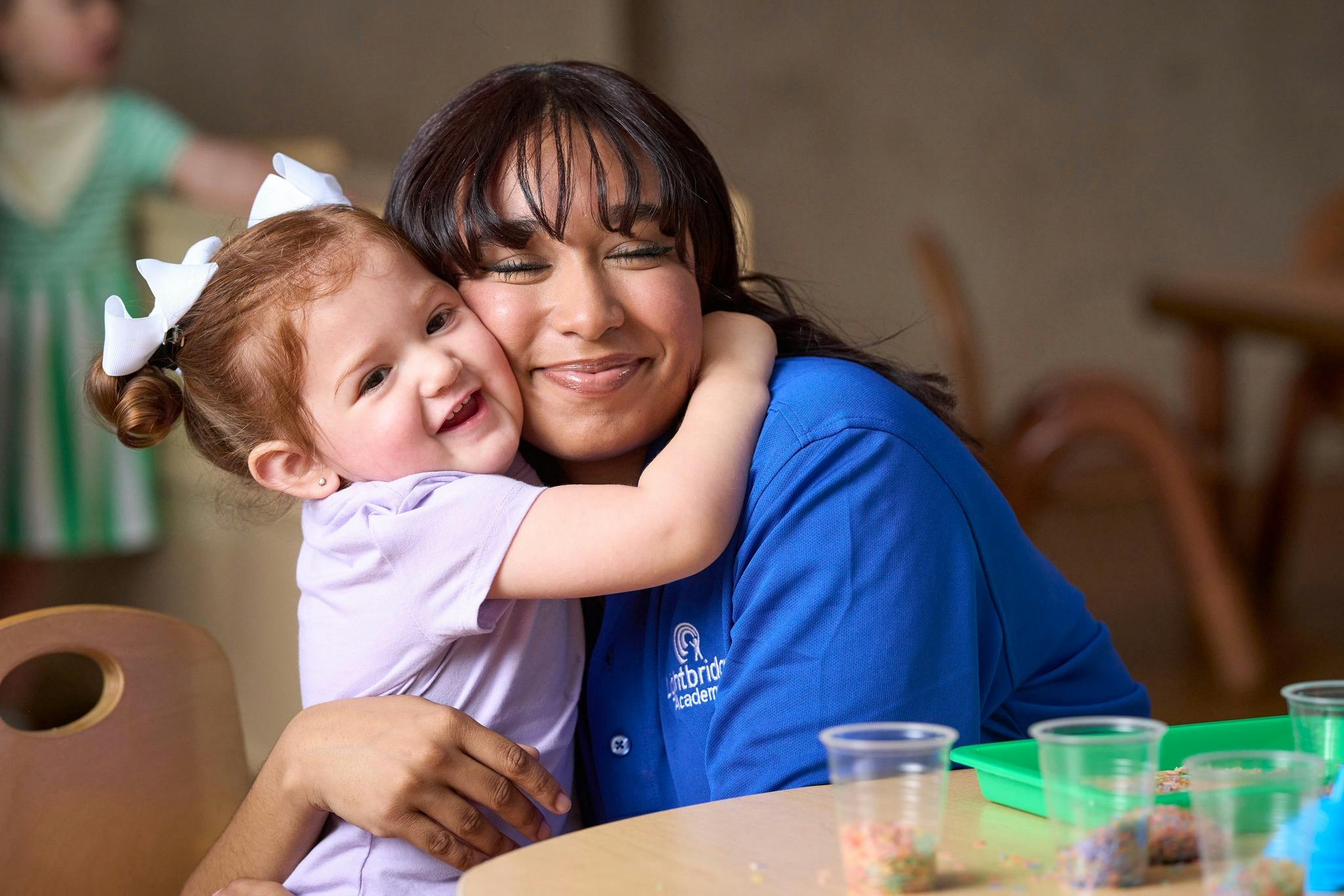 Person in blue shirt hugging a child