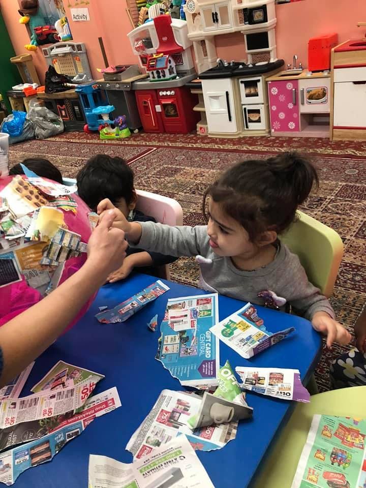 Child and person at a table with paper cutouts