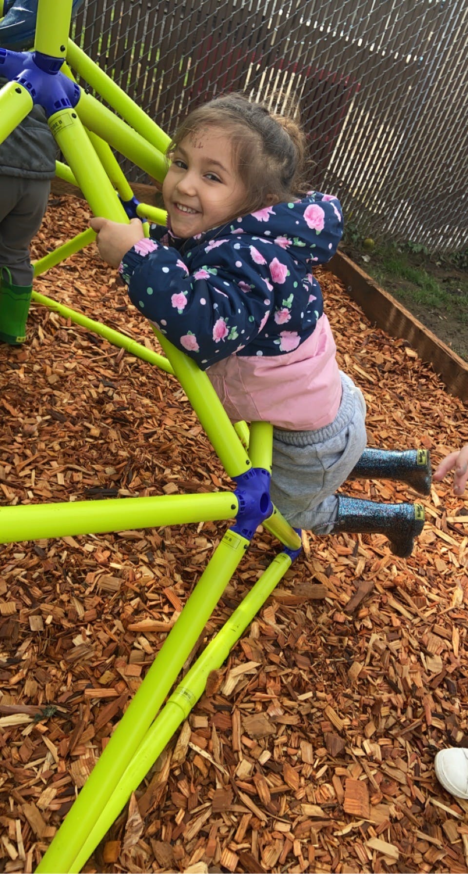 Child climbing on a green and blue playground structure