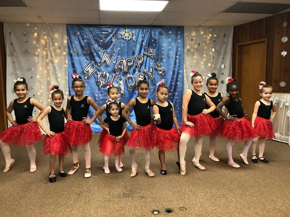 Group of children in black leotards and red tutus posing