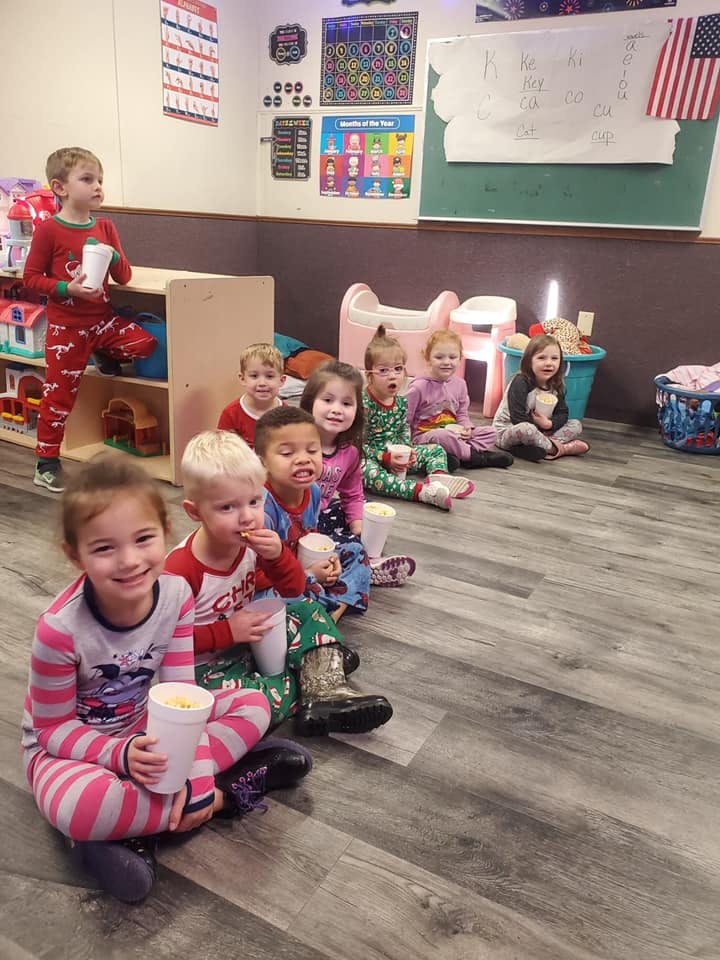 Children sitting on the floor holding cups
