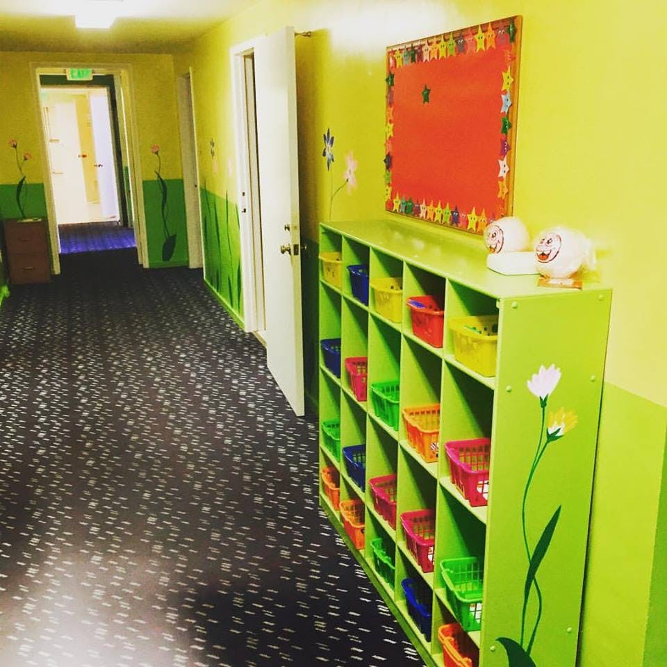 Hallway with green cubbies holding colorful baskets