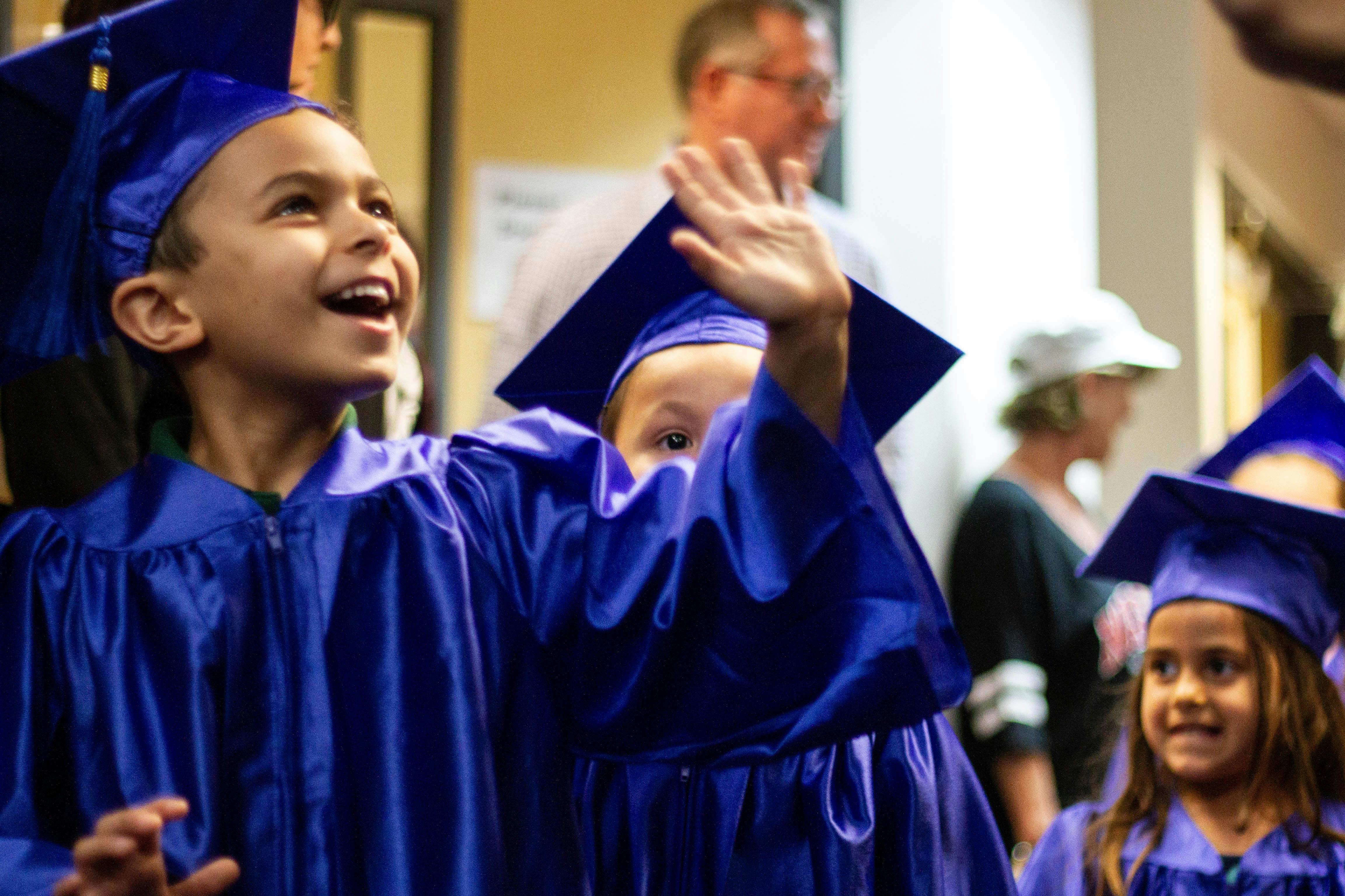 Child in a blue graduation cap and gown