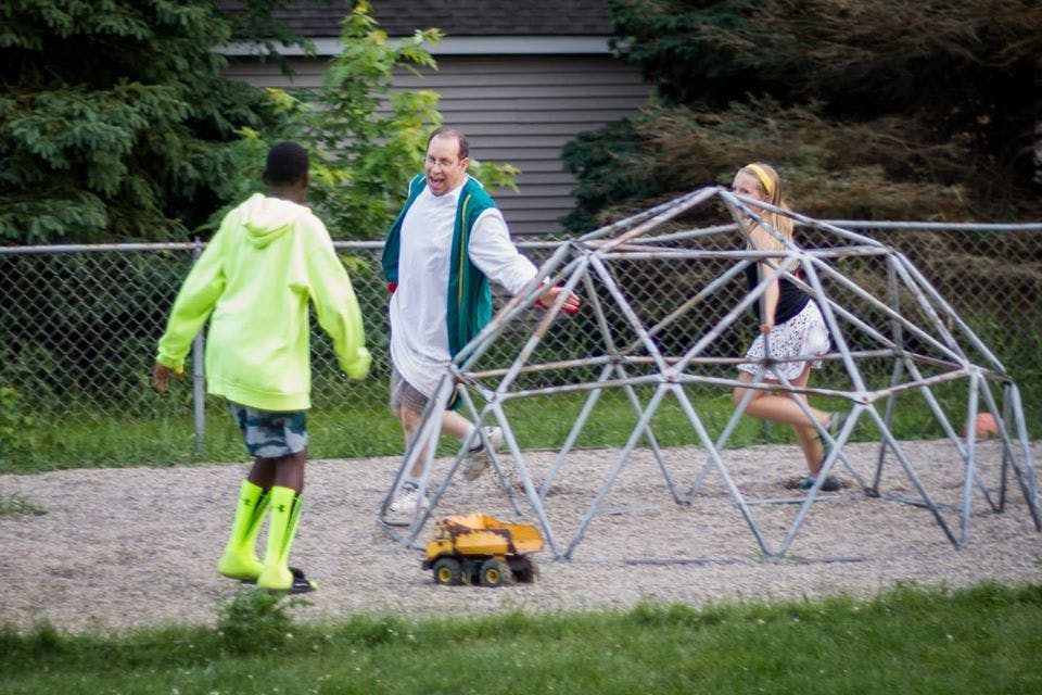 Three people playing on a geodesic dome climber