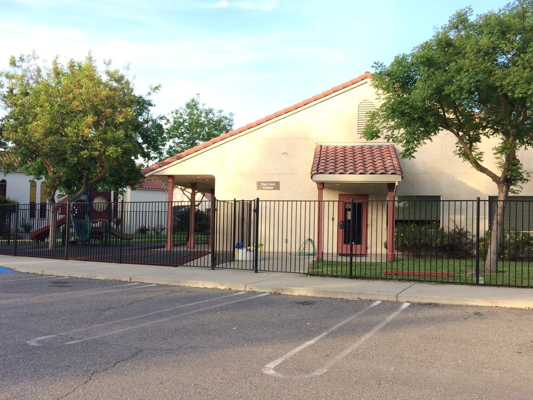 Building with a red tile roof and a black metal fence in front