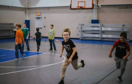 Children running on a gymnasium court
